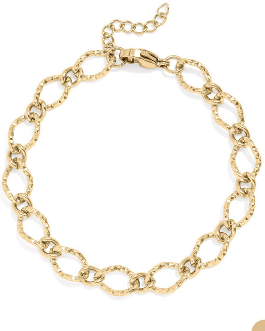 Gold hammered oval chain bracelet on a white background