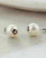 Florida State pearl stud earrings with logo on a neutral background