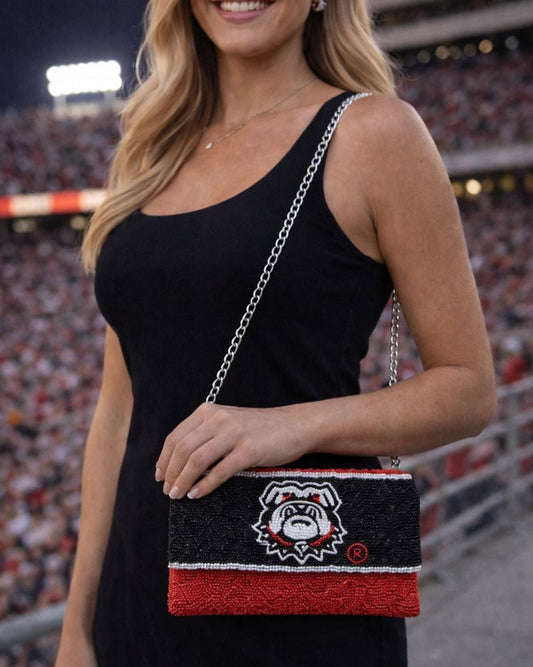 Beaded Georgia Bulldogs crossbody clutch with silver chain strap worn at a football stadium, black and red game day purse