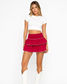 Crimson red tiered ruffle mini skirt with white crop top and white cowboy boots on white background