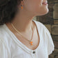Close-up of a person wearing a gold Tennessee Volunteers herringbone necklace with orange Power T pendant.