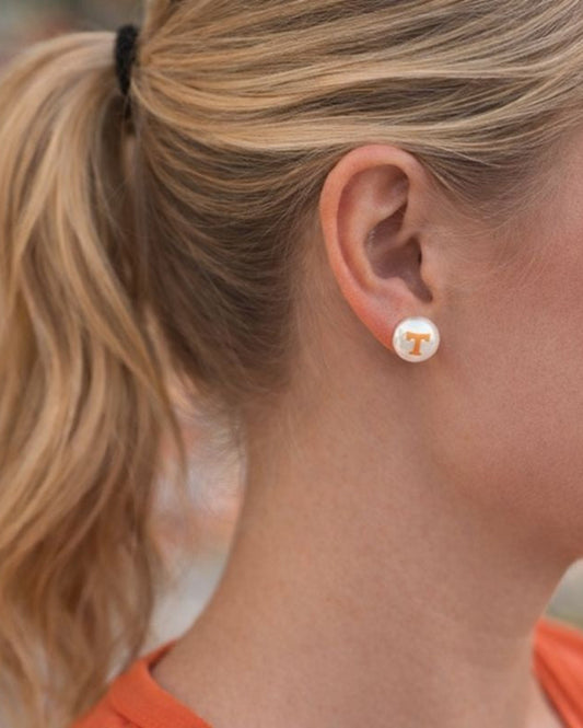 Blonde woman wearing Tennessee Vols pearl stud earrings with orange Power T logo, hair in ponytail