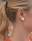 Blonde woman wearing Tennessee Vols pearl stud earrings with orange Power T logo, hair in ponytail