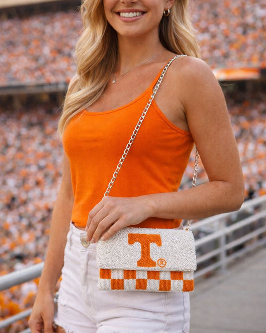 Woman wearing Beaded Tennessee Volunteers orange and white checkered crossbody game day bag at football stadium