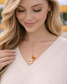 Woman wearing Tennessee Volunteers Y-necklace with gold Power T charm and orange and clear crystal accents